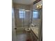Cozy bathroom features tiled walls, glass-enclosed tub/shower, and a vanity with ample counter space at 6704 Hickorywood Ln # 2B, New Port Richey, FL 34653