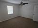 Bright bedroom featuring neutral carpet, a ceiling fan, and a window to let in natural light at 6704 Hickorywood Ln # 2B, New Port Richey, FL 34653