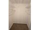 Walk-in closet features wire shelving and neutral carpet at 6704 Hickorywood Ln # 2B, New Port Richey, FL 34653