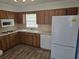 Well-lit kitchen featuring wood cabinetry, a double sink beneath a window, and a full appliance suite at 6704 Hickorywood Ln # 2B, New Port Richey, FL 34653