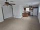 Open-concept living area with ceiling fans and a view into the adjacent kitchen with white appliances at 6704 Hickorywood Ln # 2B, New Port Richey, FL 34653
