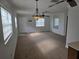 Expansive living room featuring ample natural light, neutral carpet, and ceiling fans at 6704 Hickorywood Ln # 2B, New Port Richey, FL 34653