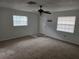 Spacious living room featuring carpeted floors, a ceiling fan, and abundant natural light at 6704 Hickorywood Ln # 2B, New Port Richey, FL 34653