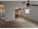 Open-concept living area with ceiling fans and a view into the adjacent kitchen with white appliances at 6704 Hickorywood Ln # 2B, New Port Richey, FL 34653