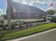 Exterior view of The Wilds Recreation Center with brick facade, mature landscaping, and an American flag at 6704 Hickorywood Ln # 2B, New Port Richey, FL 34653