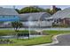 Community tennis court and green common area with a small pond and benches at 6704 Hickorywood Ln # 2B, New Port Richey, FL 34653