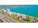Scenic aerial view features a beachfront condo community near a bay with nearby tennis court at 7432 Sunshine Skyway S Ln # 602, St Petersburg, FL 33711