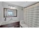 Bathroom features a vanity with granite counters, decorative mirror, and a shower with blue and white striped curtain at 7432 Sunshine Skyway S Ln # 602, St Petersburg, FL 33711