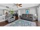 Inviting living room with a ceiling fan, a modern rug, and comfortable gray leather seating at 7432 Sunshine Skyway S Ln # 602, St Petersburg, FL 33711