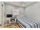 Bedroom featuring tiled floors, white ceiling fan, window with blinds, and sleek desk setup at 7615 W Osborne Ave, Tampa, FL 33615