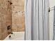 Bathroom featuring stylish tile work, showerhead and white bathtub with a decorative shower curtain at 8307 Bluevine Sky Dr, Land O Lakes, FL 34637