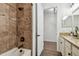 Bathroom featuring a bathtub, granite counters, shower, and a white door leading to another room at 8307 Bluevine Sky Dr, Land O Lakes, FL 34637