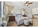 Charming bedroom with wood floors, a ceiling fan, two side tables, and stylish window treatments at 8307 Bluevine Sky Dr, Land O Lakes, FL 34637