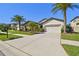 Charming single-Gathering home featuring a manicured lawn, two-car garage, and tropical landscaping at 8307 Bluevine Sky Dr, Land O Lakes, FL 34637