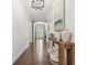 Hallway with hardwood floors, console table and decor, leading to front door with stone accent wall at 8307 Bluevine Sky Dr, Land O Lakes, FL 34637