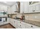 Chef's kitchen featuring stainless steel appliances, granite countertops, custom cabinetry, and a gas range for cooking at 8307 Bluevine Sky Dr, Land O Lakes, FL 34637
