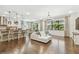 Open-concept living space with hardwood floors, a stylish island kitchen, and abundant natural light at 8307 Bluevine Sky Dr, Land O Lakes, FL 34637