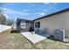 Backyard patio with furniture, leading to screened-in porch and fenced yard at 841 Petal Mist Ln, Brooksville, FL 34604