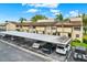 Exterior view of carport parking and a well-maintained tan apartment complex under a sunny sky at 9209 Seminole Blvd # 145, Seminole, FL 33772