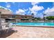Relaxing pool area with tables, chairs, and umbrellas surrounded by a well-maintained deck on a sunny day at 9209 Seminole Blvd # 145, Seminole, FL 33772