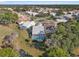 Neighborhood aerial view of a home with a screened-in pool, surrounded by lush trees and well-maintained lawns at 9339 Creole Ct, Weeki Wachee, FL 34613