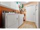 Laundry room featuring white washer and dryer, overhead cabinets and storage, and a door to the outside at 9339 Creole Ct, Weeki Wachee, FL 34613