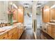 Bathroom featuring dual sinks, wood cabinets, and a mirrored wall at 9466 127Th Ave, Largo, FL 33773