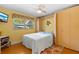 Comfortable bedroom with murphy bed, ceiling fan, wood floors, and a sunny window at 9466 127Th Ave, Largo, FL 33773