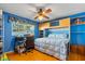 Well-lit bedroom with built-in shelving, ceiling fan, wood floors, a cozy bed, and a desk at 9466 127Th Ave, Largo, FL 33773