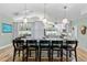 Full view of kitchen island and seating with pendant lights, skylight, and eat-in-kitchen in the background at 9466 127Th Ave, Largo, FL 33773
