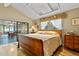 Serene bedroom with a tray ceiling, hardwood floors, and a view of the screened-in porch at 9466 127Th Ave, Largo, FL 33773