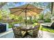 Cozy outdoor patio with dining table, umbrella, and a hot tub, all surrounded by lush landscaping at 9466 127Th Ave, Largo, FL 33773