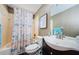 This bathroom features a shower/tub combination, a toilet, and a vanity with a dark wood cabinet and a white sink at 10603 1St St, Riverview, FL 33569