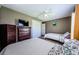 Comfortable bedroom with neutral walls, a ceiling fan, two beds, and wood furniture at 10603 1St St, Riverview, FL 33569