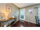 Inviting entryway with warm wood flooring, console table decor, and a bright, welcoming door at 10603 1St St, Riverview, FL 33569