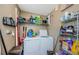 Functional laundry area equipped with a washing machine, dryer, shelving, and storage for supplies at 10603 1St St, Riverview, FL 33569