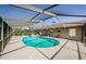 Screened-in pool area featuring a kidney-shaped pool, patio, and partially shaded seating area at 10603 1St St, Riverview, FL 33569