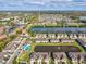 Aerial view of townhome community featuring pool, lake, and lush greenery on a beautiful sunny day at 11641 Crowned Sparrow Ln, Tampa, FL 33626
