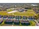 An aerial view of townhomes, a school with playing fields, and manicured green spaces at 11641 Crowned Sparrow Ln, Tampa, FL 33626