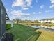 Lush backyard of a lakeside townhome with view of lake and surrounding townhomes on a partly cloudy day at 11641 Crowned Sparrow Ln, Tampa, FL 33626