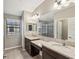 Bright bathroom with dual sinks, granite countertops, and a large mirror, offering a stylish space at 11641 Crowned Sparrow Ln, Tampa, FL 33626