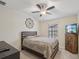Comfortable bedroom with ceiling fan, window, TV, and charming decorative wall medallion at 11641 Crowned Sparrow Ln, Tampa, FL 33626