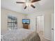 Relaxing bedroom with a window, TV, ceiling fan and adjacent walk-in closet at 11641 Crowned Sparrow Ln, Tampa, FL 33626