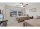 Comfortable bedroom with two twin beds, neutral decor, and plenty of natural light from the large windows at 11641 Crowned Sparrow Ln, Tampa, FL 33626
