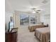Inviting bedroom featuring twin beds, a ceiling fan, and a dresser, perfect for a restful night's sleep at 11641 Crowned Sparrow Ln, Tampa, FL 33626
