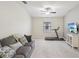 A cozy bonus room with a sofa, treadmill, ceiling fan, and a TV for relaxation and exercise at 11641 Crowned Sparrow Ln, Tampa, FL 33626
