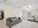 Spacious bonus room featuring a comfortable sofa, ceiling fan, and a treadmill for a dedicated workout area at 11641 Crowned Sparrow Ln, Tampa, FL 33626