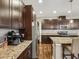 Kitchen with dark wood cabinets, granite countertops, stainless appliances, and island seating at 11641 Crowned Sparrow Ln, Tampa, FL 33626