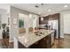Kitchen island features stainless steel sink, granite countertops, stainless steel appliances, and dark cabinets at 11641 Crowned Sparrow Ln, Tampa, FL 33626