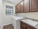 The laundry room has a modern washer and dryer, storage cabinets and sink at 11641 Crowned Sparrow Ln, Tampa, FL 33626